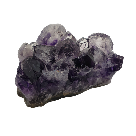 A piece of amethyst with dark purple points on a base of grey stone