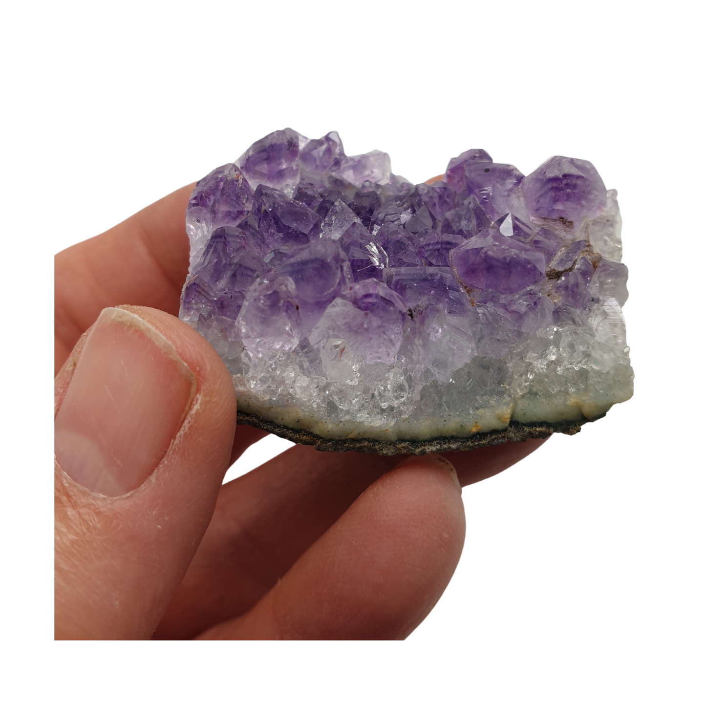 A hand holding a piece of amethyst with purple points on a base of grey stone