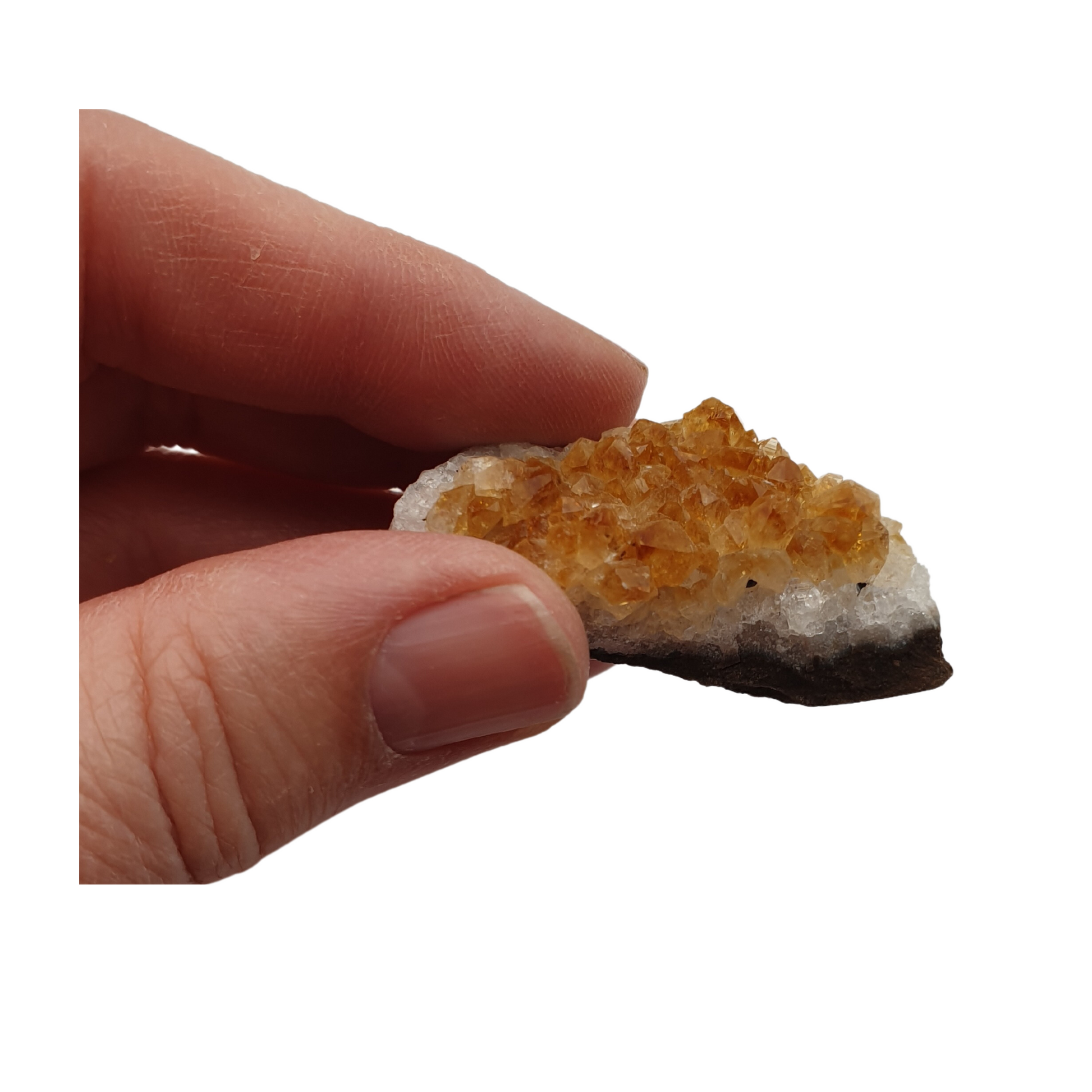 A hand holding a piece of citrine crystal with golden yellow points and a white base