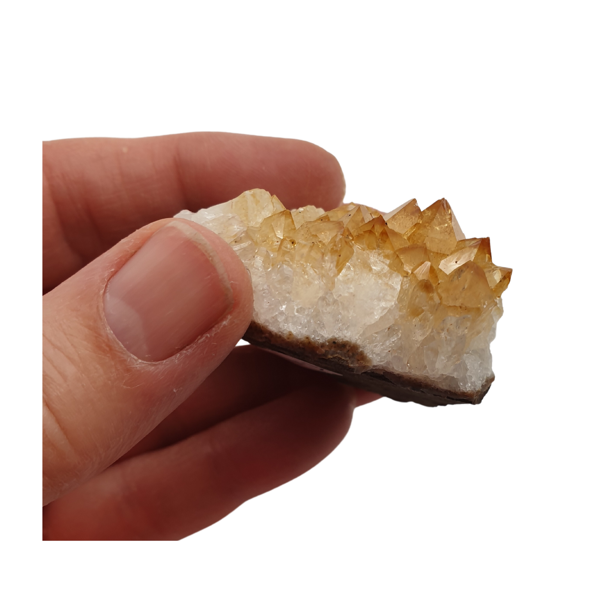 A hand holding a piece of citrine with golden yellow points and a white base