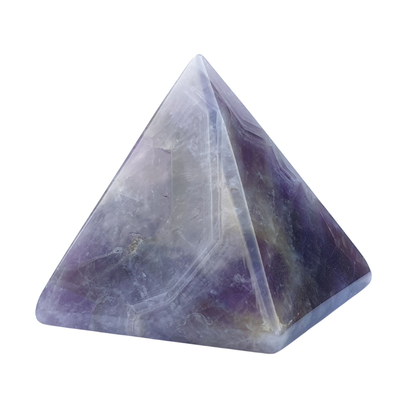 An amethyst crystal carved into a pyramid on a white background